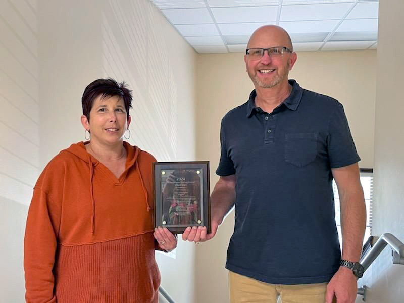 Man and woman holding award plaque